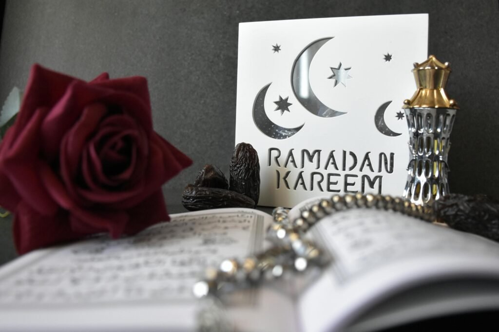 A stylish Ramadan Kareem greeting with a rose, prayer beads, and decorative elements, perfect for festive occasions.